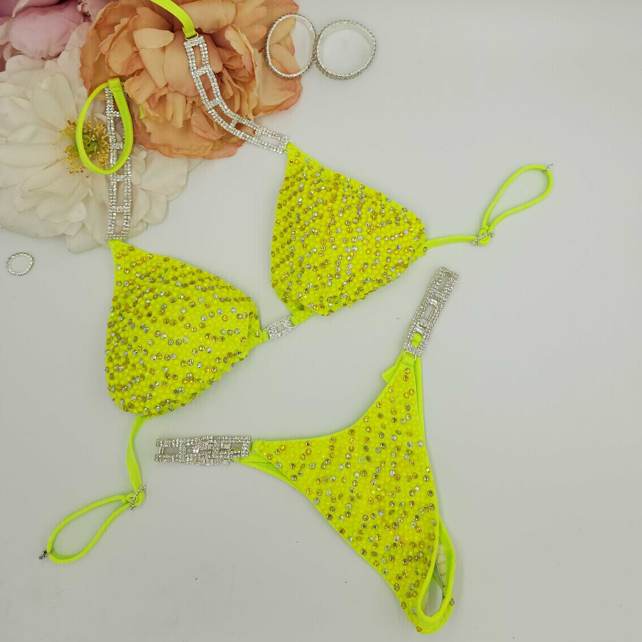 Neon green bikini set with rhinestone details on a white surface.
